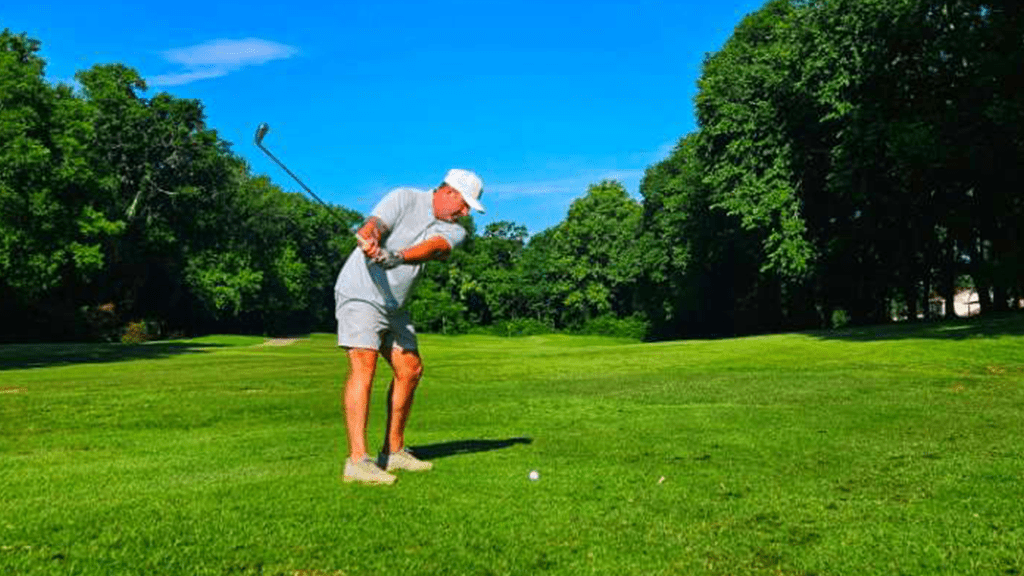 Golfer taking a swing on fairway